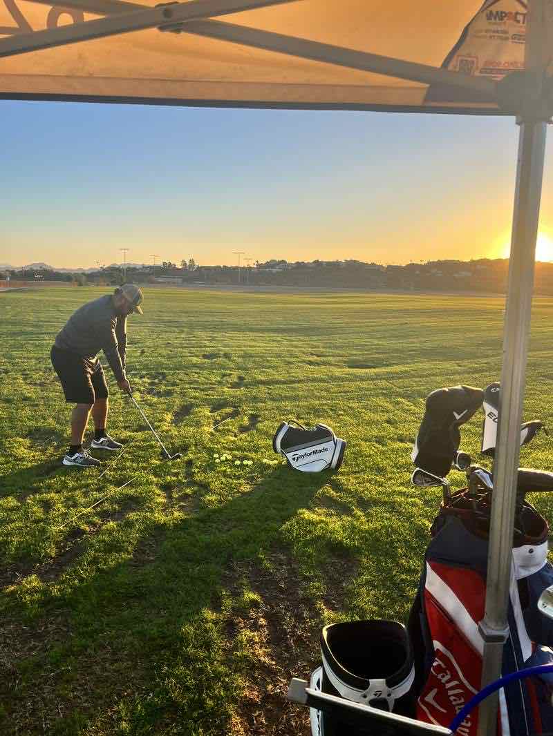 Golf lesson at sunset with alignment sticks